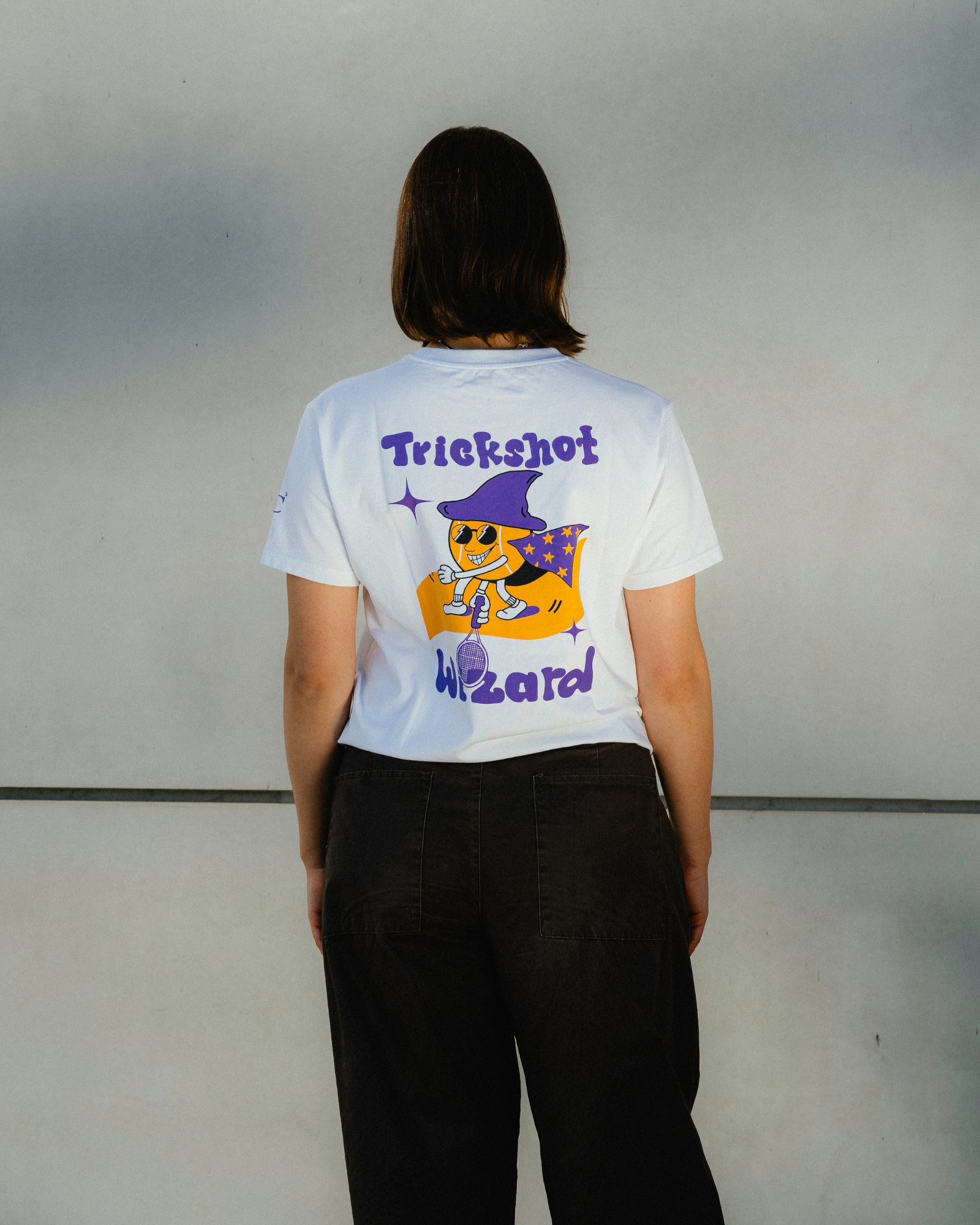 Trickshot Wizard Tee getragen auf dem Tennisplatz