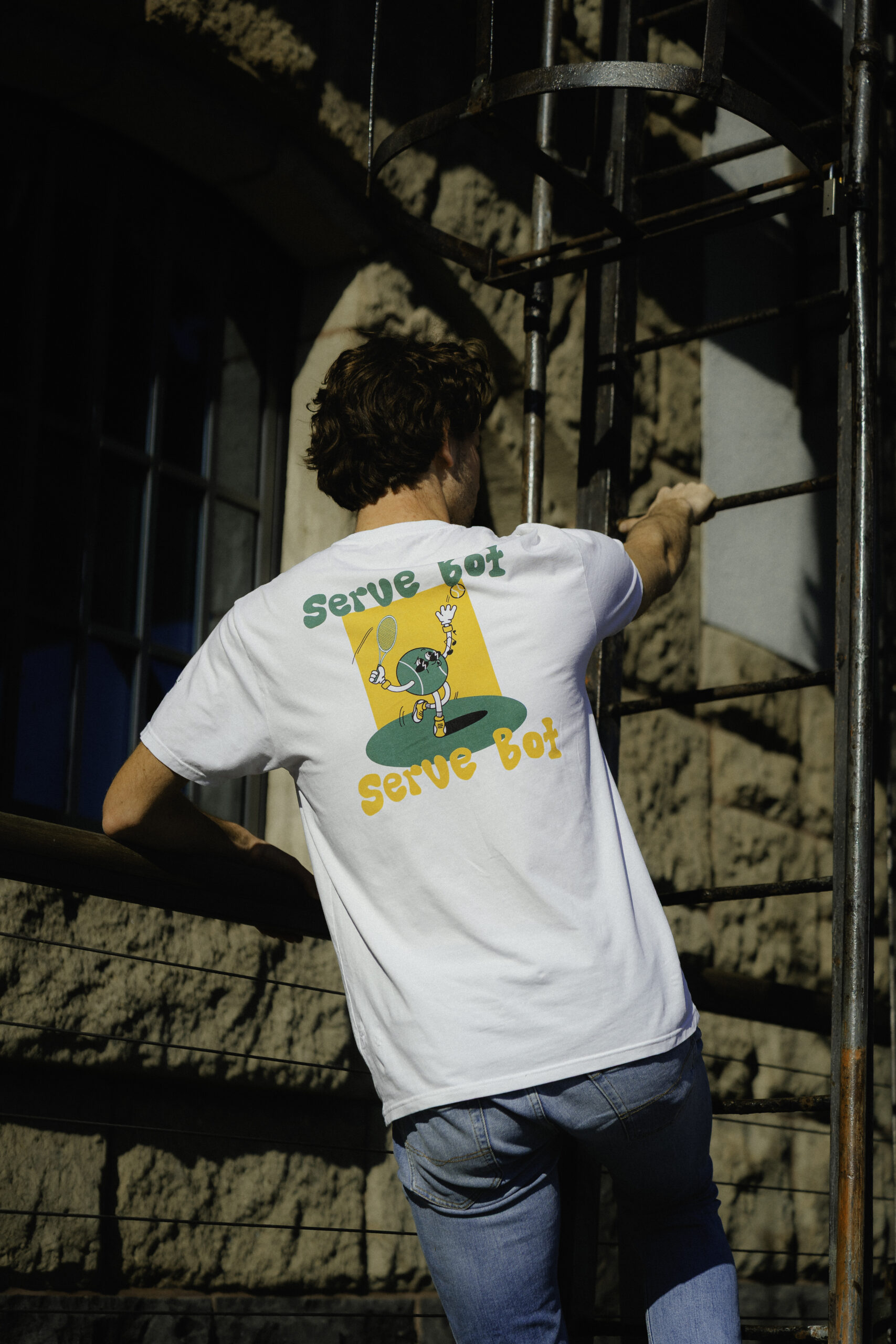 Serve Bot Tee getragen im urbanen Tennis-Kontext